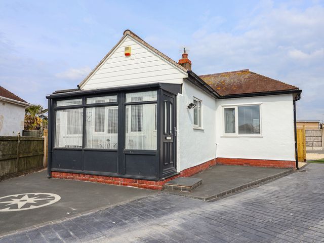 A house with a front porch and driveway at Driftwood in Rhyl