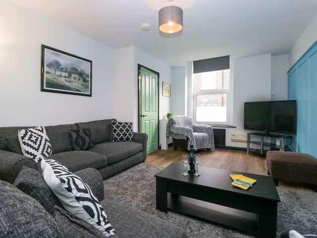 A living room with a sofa and television at Havelock Hideaway in Windermere