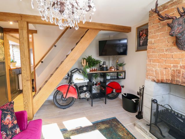 A living room with a motorcycle and chandelier at 7 The Row in Grantham