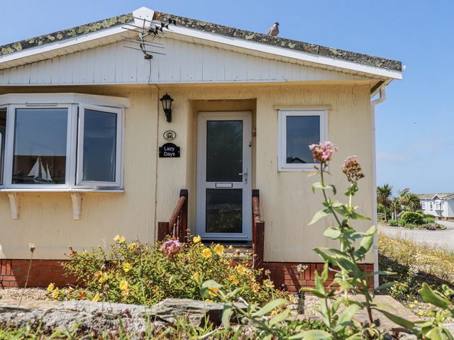 A house exterior with a sign at Lazy Days in St Merryn