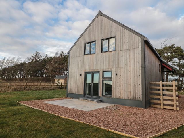A house with large windows and a patio at Harvest Cottage 2 in Berwick-upon-Tweed