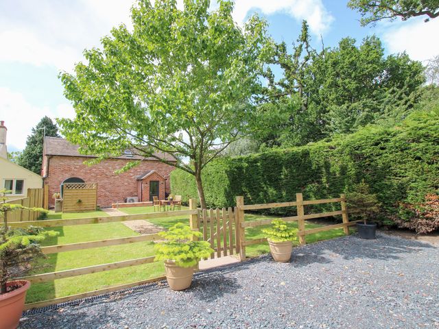 A garden with a tree and fence at Sylva Cottage in Burlton near Cockshutt