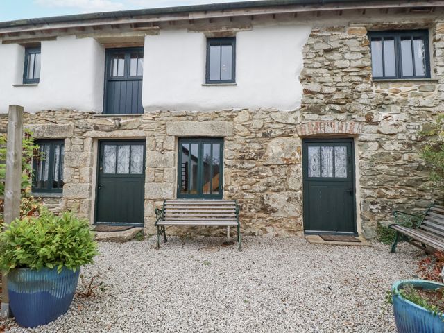 An outdoor area with stone walls and doors at Coombe Barn in Cusgarne near St Day