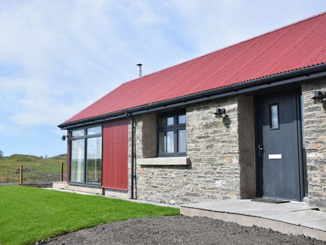 An exterior view of a house with a red roof and stone walls at The Old House, Balure Lismore