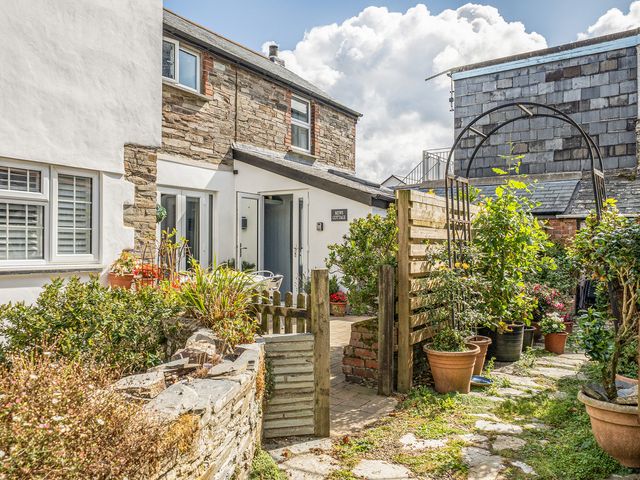 A garden with plants and a gate at Mews Cottage Tintagel