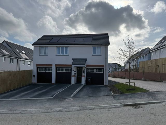 A house with garages and solar panels at Yonja Homes in St Austell
