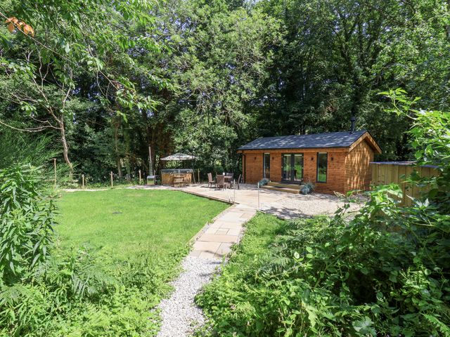 An outdoor area with a wooden cabin and seating at Roe Deer Lodge in Littlebeck near Sleights