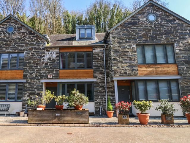 Exterior view of a stone house with planters at 8 Pottery Cottages
