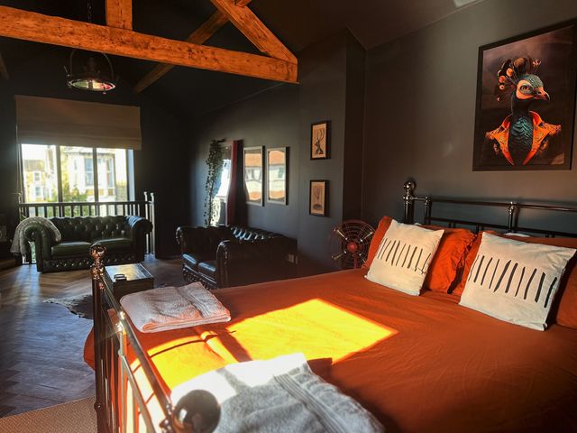 A bedroom with a bed and sofas at The Balmoral Coach House in Morecambe