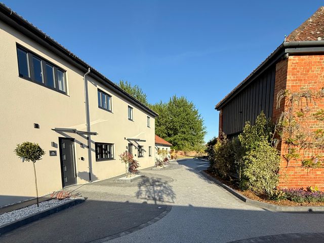 An outdoor view of buildings and landscaped pathway at Pine Lodge in Bridgwater