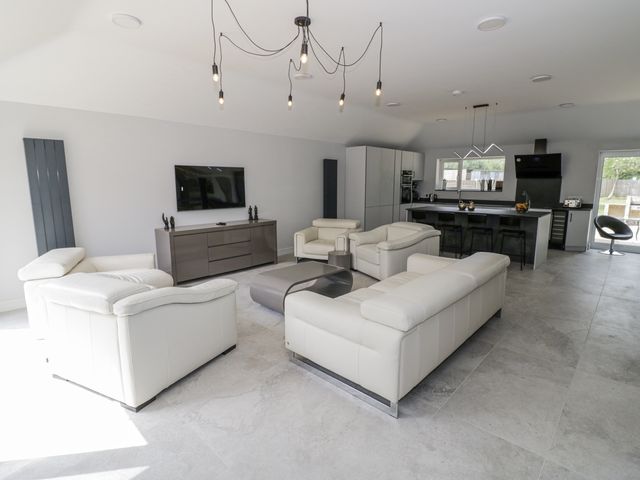 A living room with a television and kitchen island at Chillon South Littleton near Honeybourne