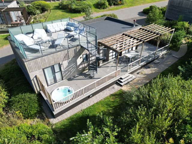 A house with an outdoor seating area and hot tub at The Black Barnacle in Portreath