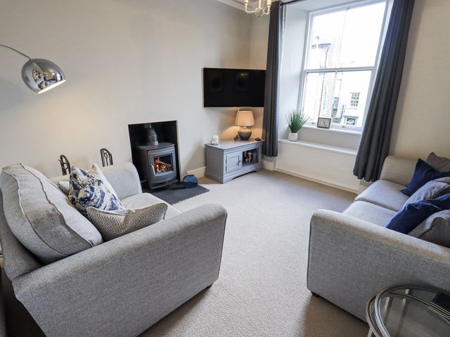 A living room with a television and fireplace at Olive Cottage in Kirkby Stephen
