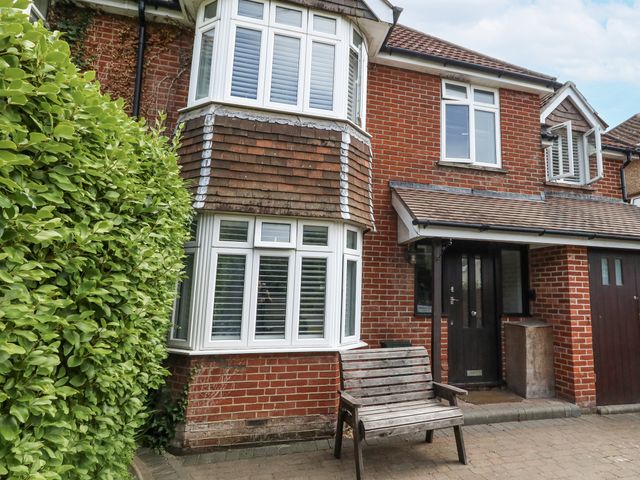 A house with a bench in front and a garage door at King Henry House in Lymington