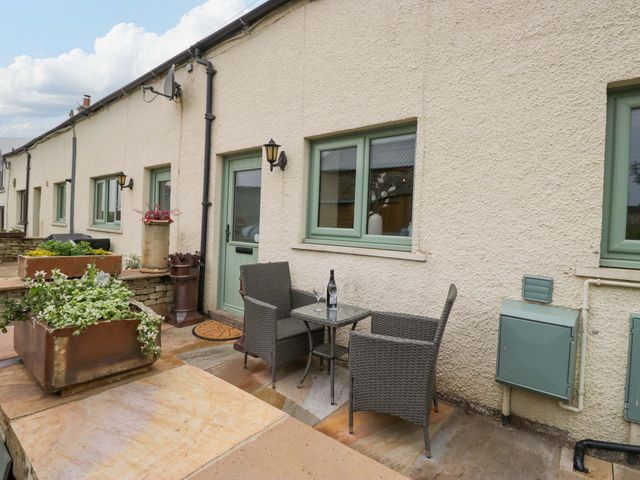 An outdoor seating area with a table and chairs at Yeat Stoup Cottage in Cockermouth