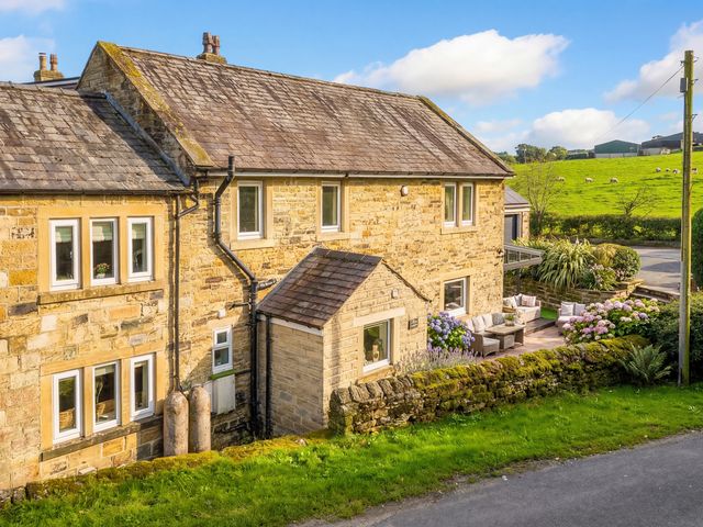 A stone house with garden furniture at Johns Cottage in Hampsthwaite
