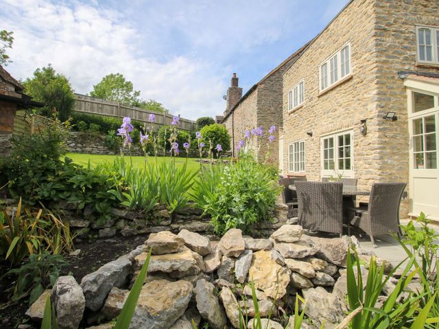 A garden with flowers and seating area at 5 Shrewsbury Road Much Wenlock