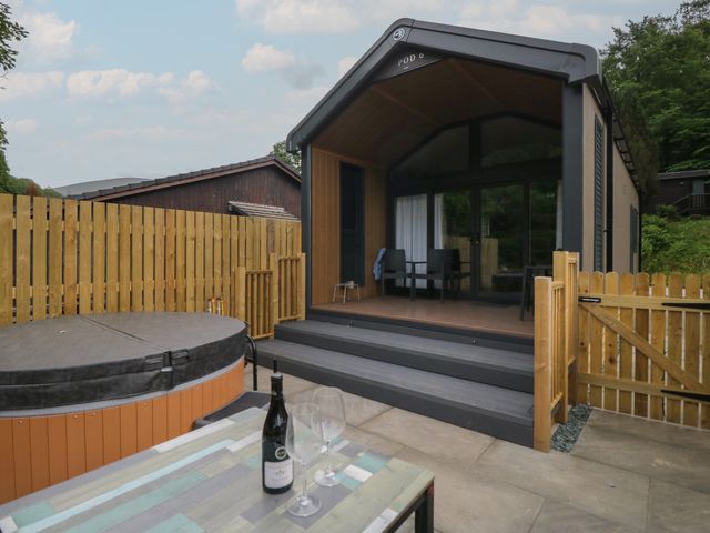 An outdoor area with a hot tub and seating at Woof Luxury Family Pod in Keswick