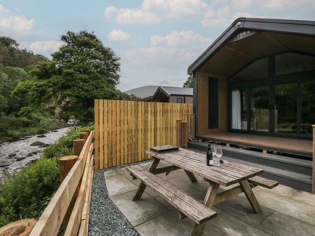 An outdoor area with a picnic table and wine setup at Sail Luxury Family Pod in Keswick