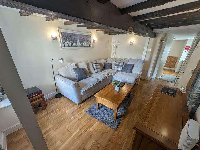 A living room with a sofa and coffee table at Hocking Cottage St Marychurch