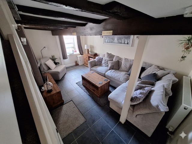 A living room with a coffee table and sofa at Hocking Cottage St Marychurch
