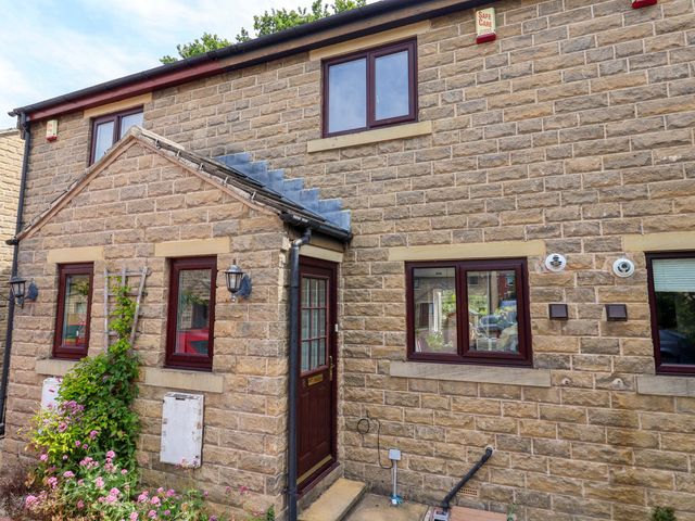A front exterior view of a house with a door and windows at 8 Wharfedale Mews Otley
