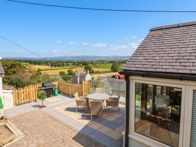 A patio area with a table and chairs at Ael Y Bryn Dyserth