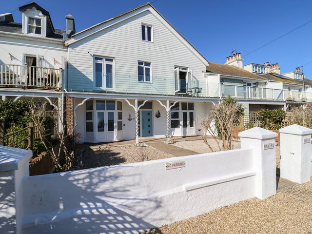 A white two-story house with a gravel front yard and a no parking sign at Marine House in Pevensey Bay