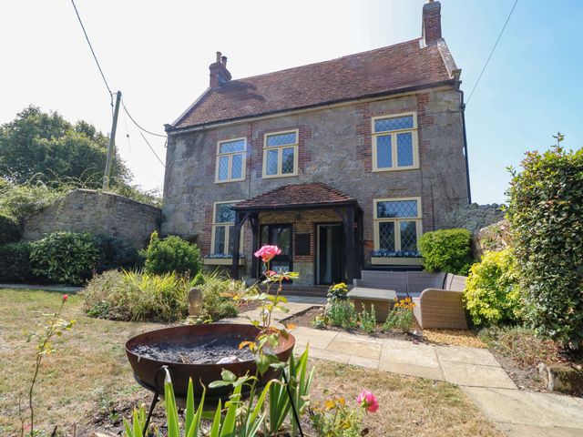 A house with a garden and seating area at Glebe Garth in Chale near Niton