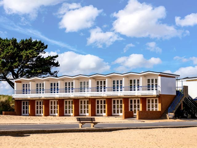A row of beach huts in front of sand at Seaheaven