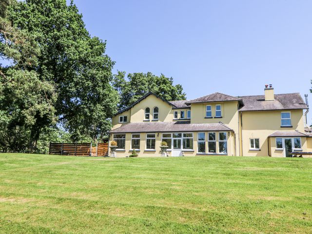 A house with windows and grass area at Glanrannell Park House Llanwrda
