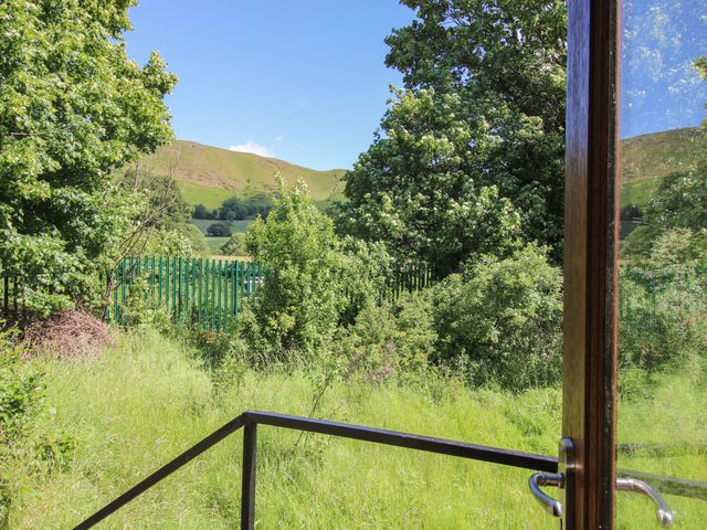 A view of trees and hills from a gate at The Miller’s Roost at Dudgeley Mill All Stretton near Church Stretton