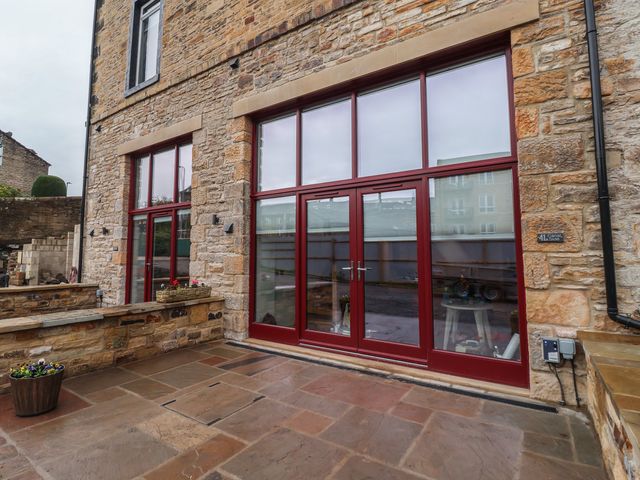 An outdoor area featuring large windows and stone walls at Canal Side Skipton