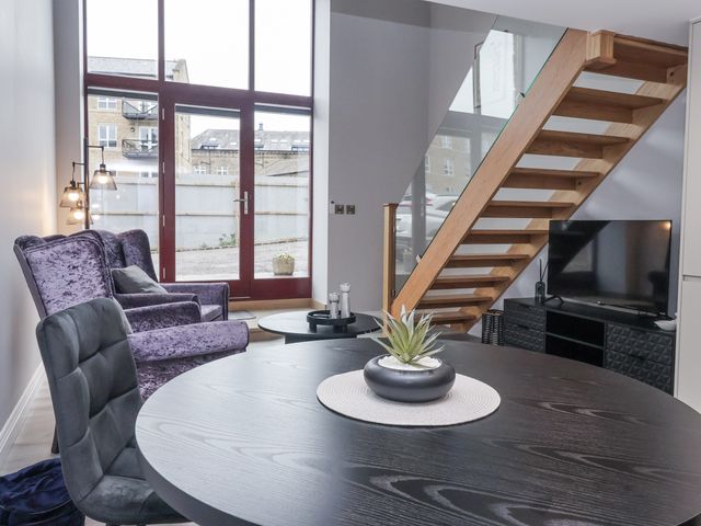 A living room with a table and sofa at Waters Edge in Skipton