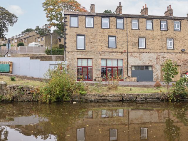 An exterior view of a building and reflection in water at Waters Edge in Skipton