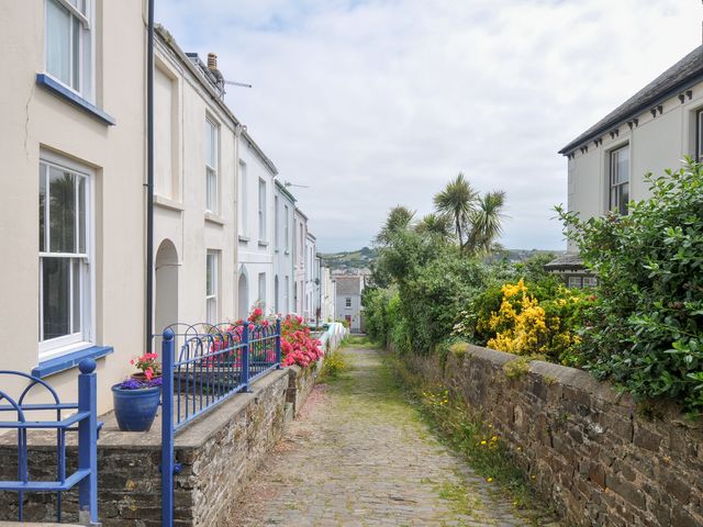A view of houses and a paved path surrounded by flowers at 12 Alpha Place Appledore
