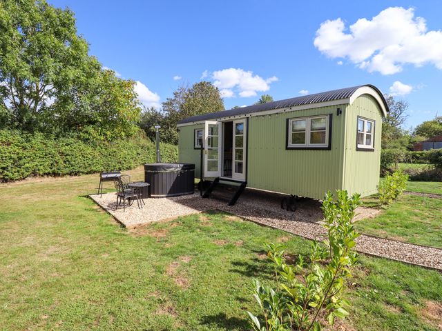 A shepherd hut with hot tub and outdoor seating at Snowdrop in Grimsby