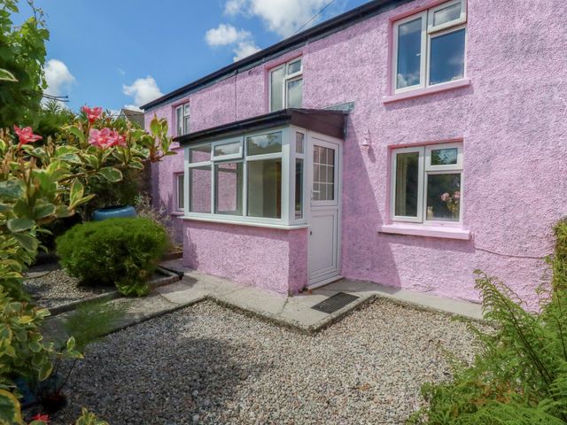 A house with pink exterior and windows at Brockstone Cottage in St Austell