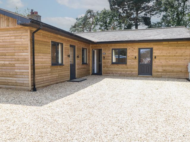 An exterior view of a wooden building with gravel at Barn Owl Lodge