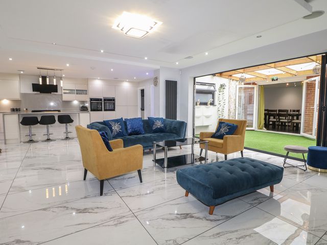 A living room with a sofa and armchairs leading to a dining area at Falcon Bal House