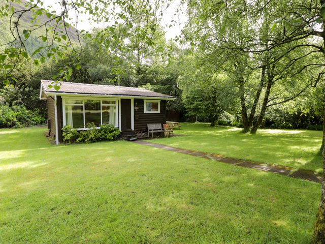 A cabin with a pathway and chairs in a garden at Ty Bedwen Dinas Mawddwy