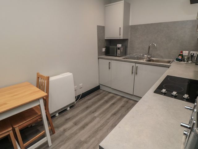 A kitchen with a table and chair at The Newborough Apartment 1 in Scarborough