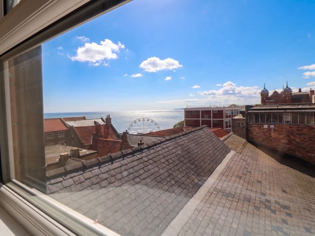 A view of the sea and buildings from a window at The Newborough Apartment 4 Scarborough