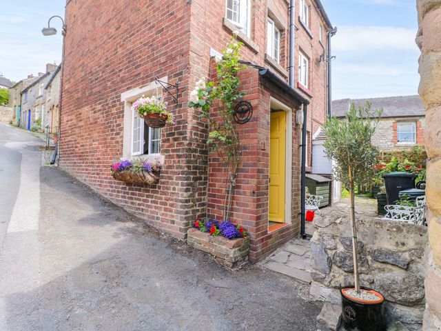An exterior view of a brick building with flowers and plants at The Beehive in Wirksworth