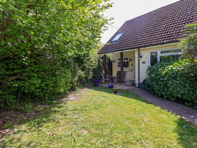 A garden with a house and trees at Rosemarie Annexe in Axminster