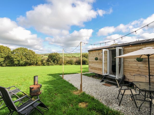 An outdoor area with seating and a cabin at Buzzards Lodge in Roche