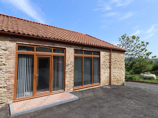 An outdoor space with a brick wall and windows at Birch Cottage in Scarborough