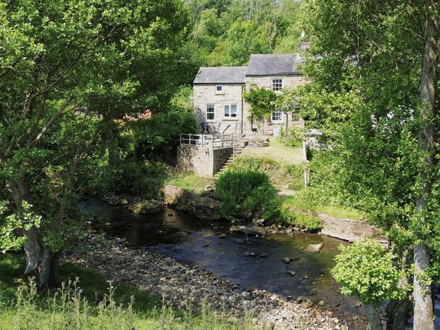 A house with a garden next to a stream at Whinstone Cottage Esk Valley near Grosmont