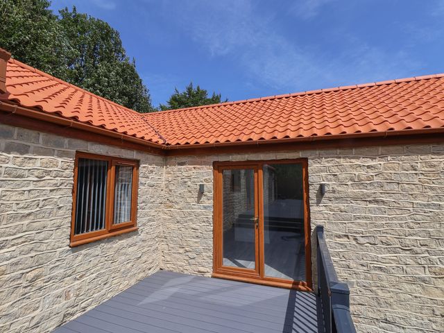 A deck with stone walls and a glass door at Castle View in Scarborough