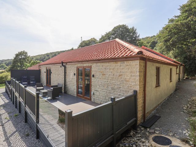 An outdoor area with a deck and chairs at Castle View in Scarborough